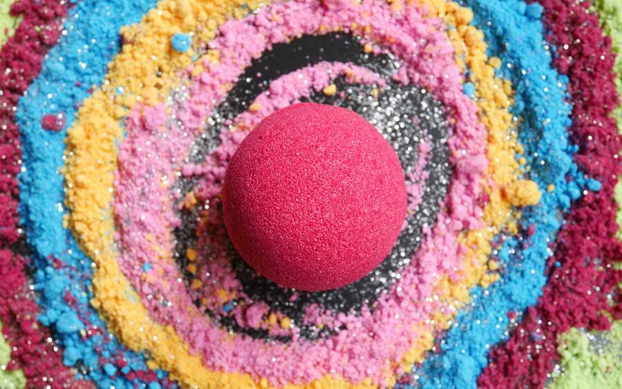 A bath bomb sits within a colorful swirl of the substances it's comprised of that may irritate your skin. 