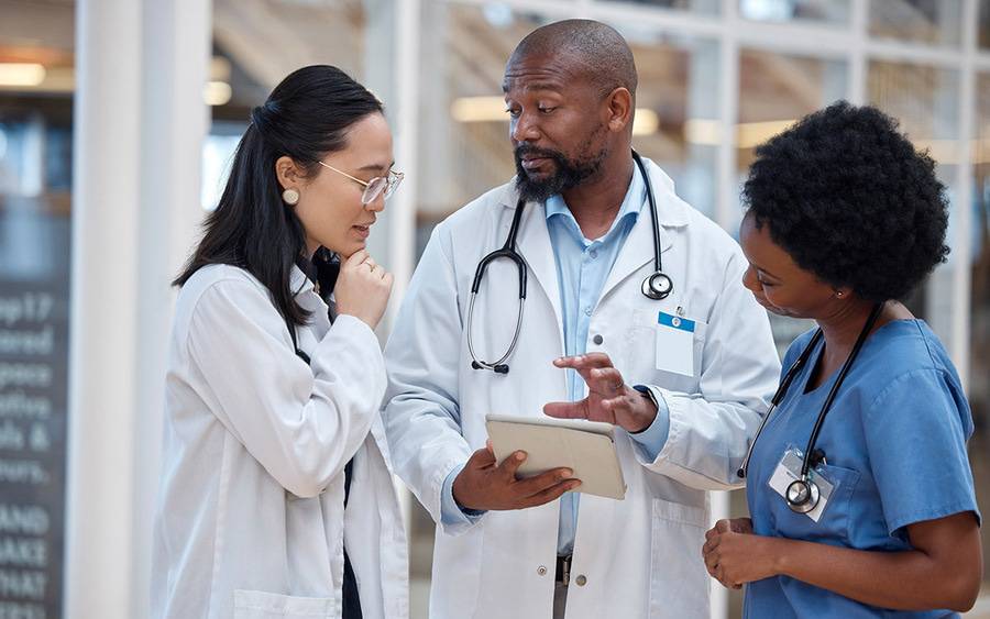 A diverse group of providers consulting each other about a patient, illustrating a patient's care team.