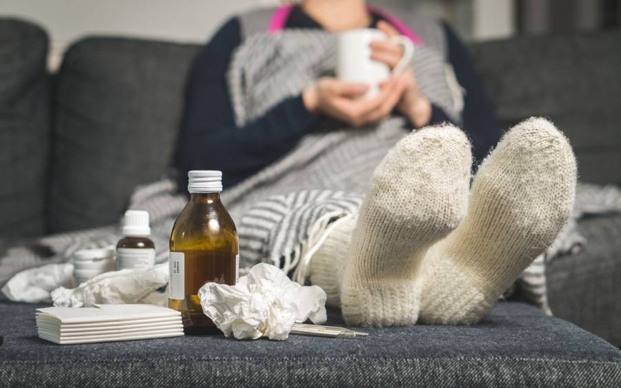 A woman with a contagious illness isolates at  home to prevent spread of illness.