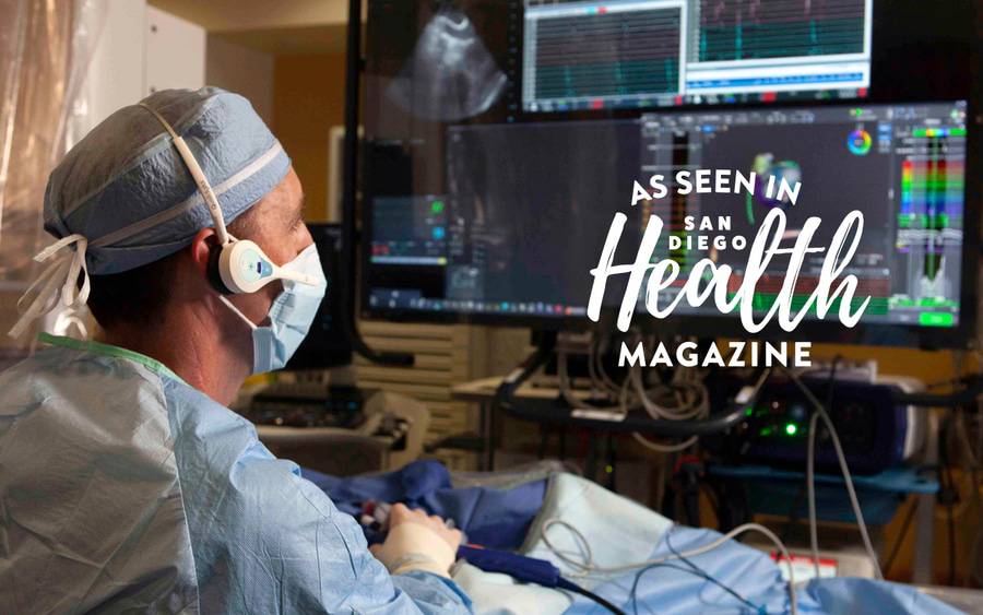 A surgeon monitors a patient's lung activity after receiving a pacemaker on multiple computer screens. San Diego Health Magazine