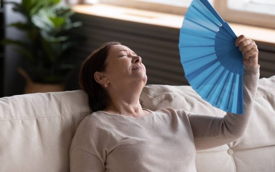 A heart patient cools off with a fan during  hot weather.