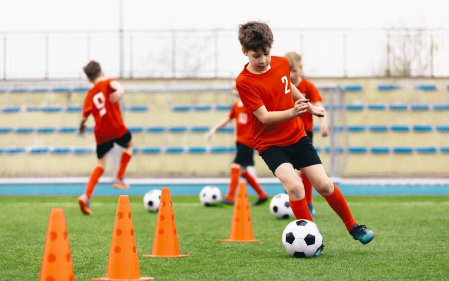 Young children learning to play soccer the right way to prevent injuries.