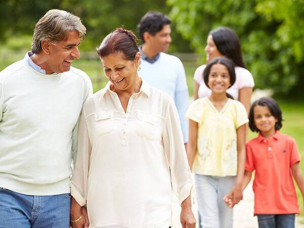 A happy couple holding hands and walking, represents healthy lifestyle that may come with attending the matter of balance program at Scripps Health in San Diego.