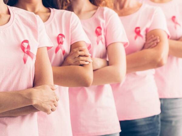 Women wearing breast cancer ribbons, a reminder of the importance of mammograms and early detection.