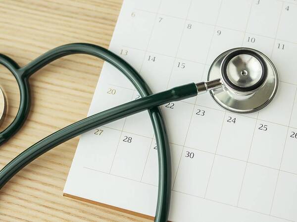 Stethoscope and calendar, reminder to schedule annual physical.