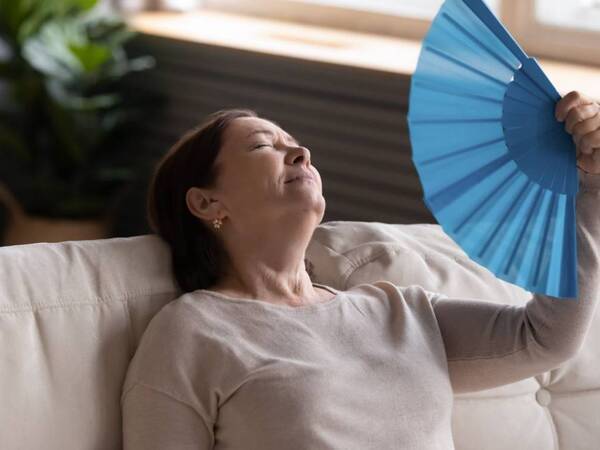 A heart patient cools off with a fan during hot weather.