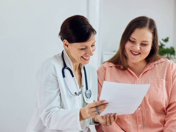 A pregnant woman discusses her health with her OB-GYN.