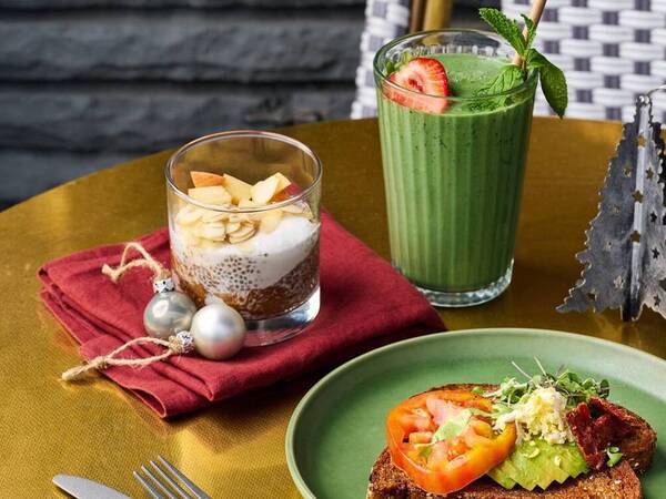 Avocado toast, vanilla chia seed pudding and a tropical smoothie set on a festive holiday decorated table.