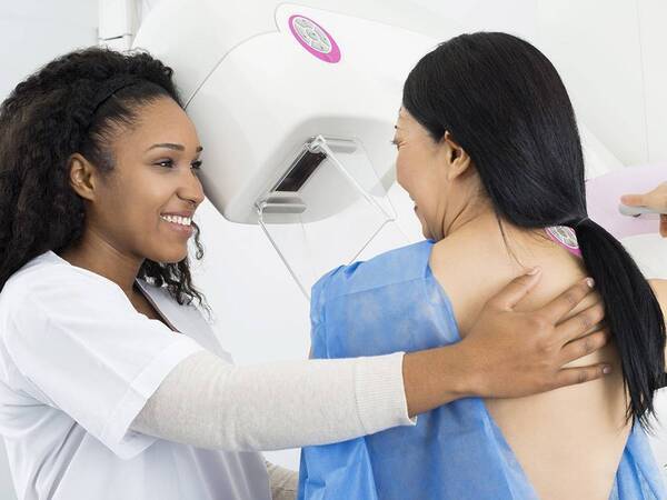 Middle-aged Asian woman gets a mammogram to detect breast cancer.