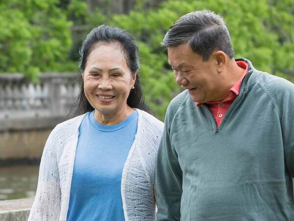 A smiling mature Asian couple represents the power and value of knowing skin cancer symptoms.